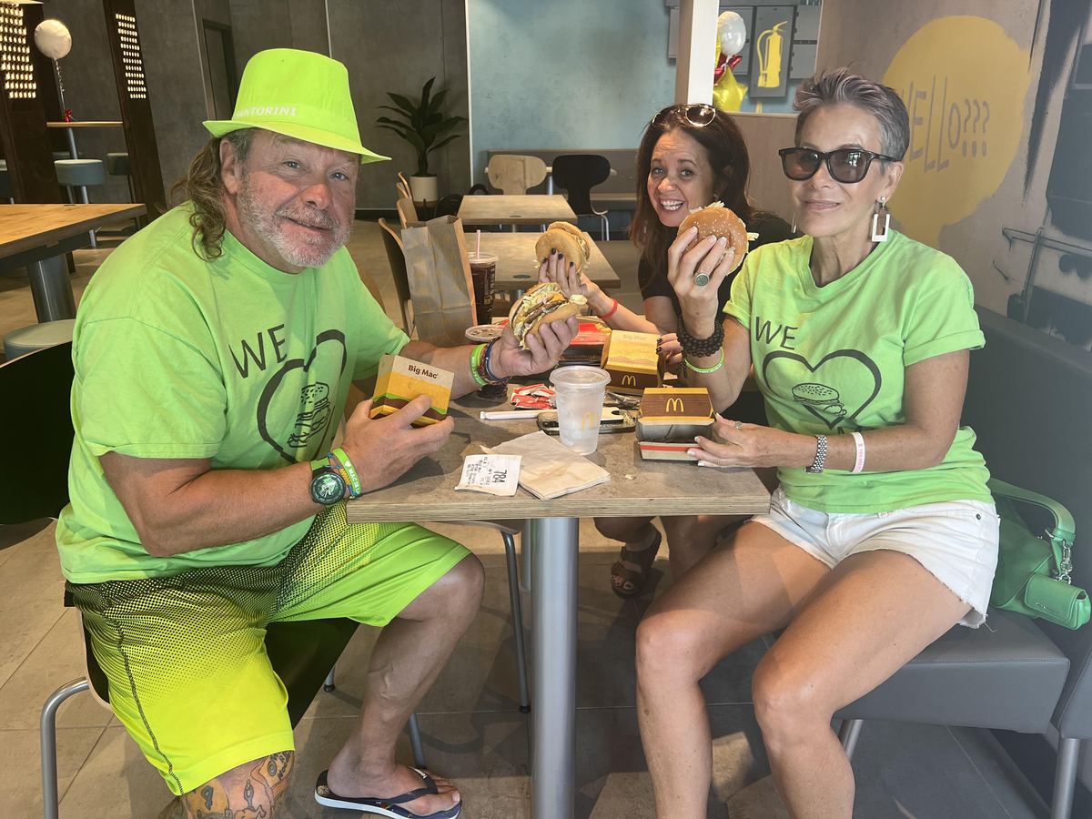 The Parkman family in bright green We Love Mac shirts eating Big Macs at McDonald's