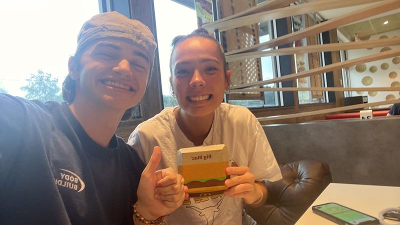 Two young people with Big Mac boxes at a restaurant
