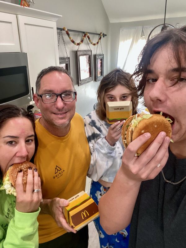 Family of four eating Big Macs in their kitchen