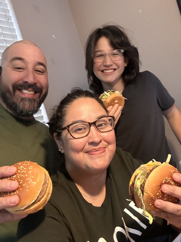 Family holding Big Macs and smiling