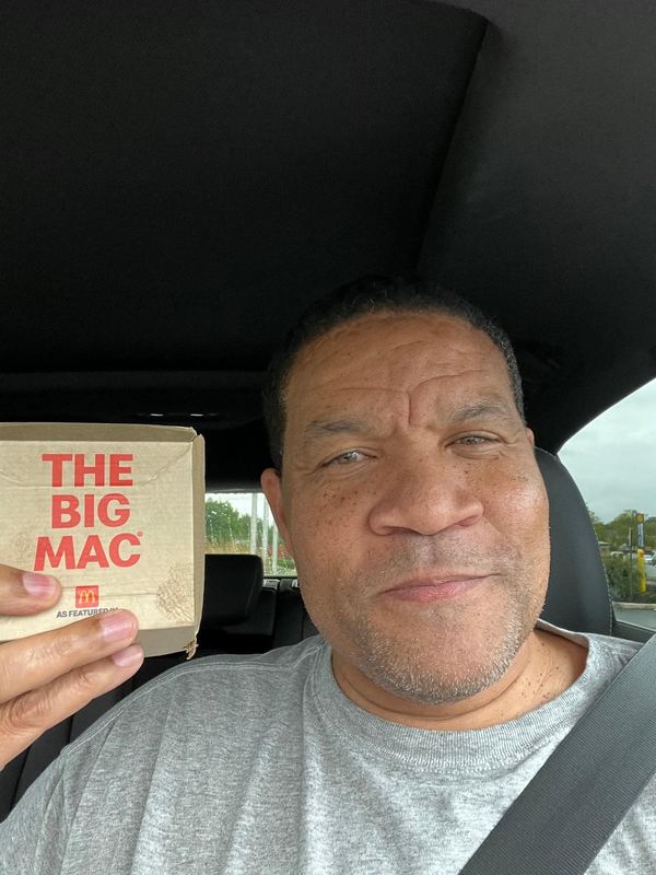 Supporter in a cap holding a Big Mac box