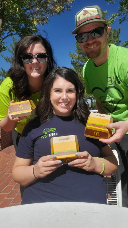 Three friends in green holding Big Mac boxes